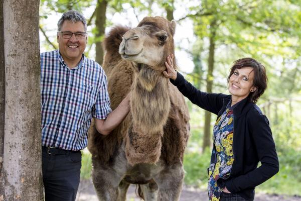 Open Farm Manager Inge Kindt and Johan Vanroye, Regenboog with one of the dromadaries